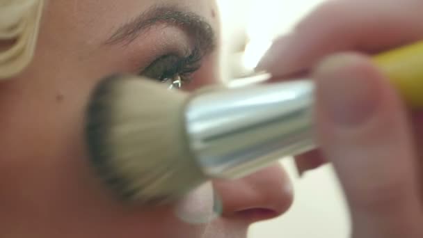 Kosmetikpuder mit einem großen Pinsel auf das Gesicht auftragen — Stockvideo