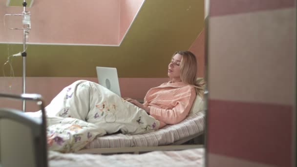 Mujer usando portátil en cama de hospital — Vídeos de Stock