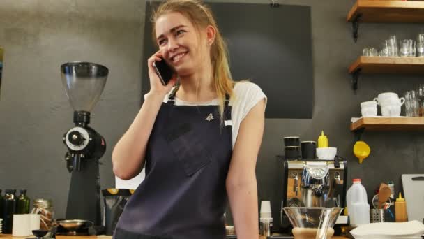 Mujer joven llamando usando el teléfono celular en el lugar de trabajo — Vídeo de stock