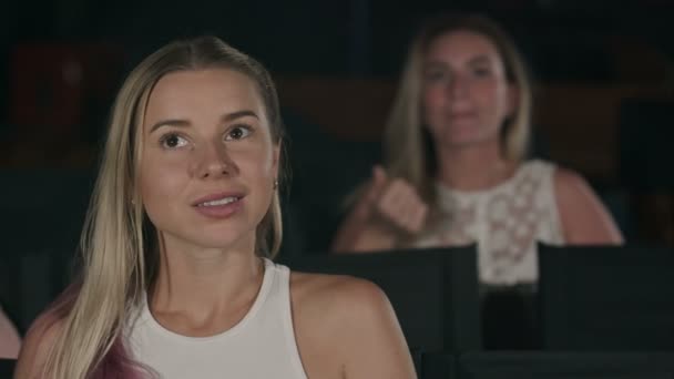Junge Frau sieht Film im Kino — Stockvideo
