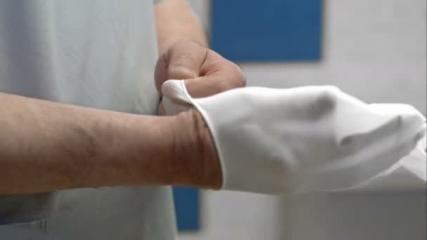 Arzt zieht weißen sterilisierten Operationshandschuh an — Stockvideo