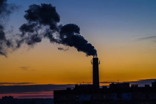 Akşam gökyüzü karşı bir borudan duman