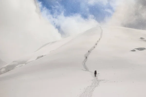 Una cadena de escaladores subiendo a la cima de la montaña — Foto de Stock