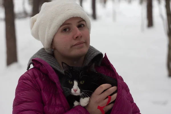 Genç bir kız ile bir kedi bir kış Ormanda yürür