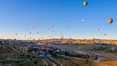Kapadokya Türkiye 'de kayaların üzerinde uçan sıcak hava balonu