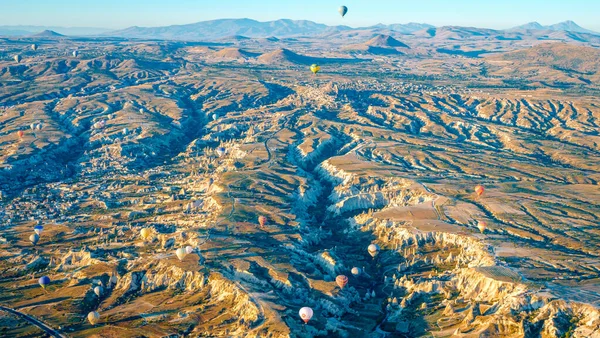 Aerial view of air balloon over fields, Cappadocia, Turkey. Aerial summer view from air balloon over road in Goreme, Cappadocia, Turkey. Aerial balloon over mountains at sunrise, Cappadocia, Turkey. — Stock Photo, Image