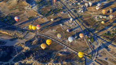 Kapadokya Türkiye 'de kayaların üzerinde uçan sıcak hava balonu