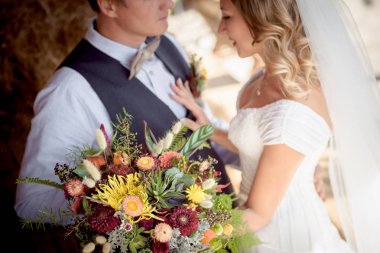 Gelini bir beyaz elbise ve damat yelek ayakta yeşil bahçe