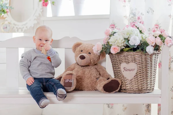 Niño pequeño con osito de peluche sentado en un jardín de bálsamo —  Fotos de Stock