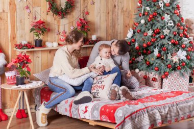 Noel ağacı evde yakınındaki bir yatakta mutlu aile