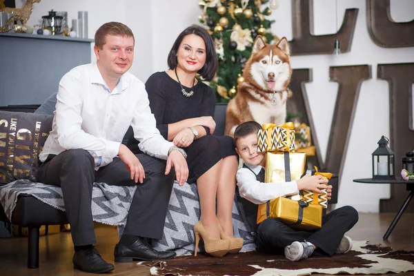 Ευτυχισμένη οικογένεια και Σιβηρία σκύλος χάσκεϋ γύρω από το χριστουγεννιάτικο δέντρο — Φωτογραφία Αρχείου