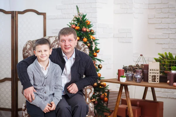Far och ung son nära dekorerad julgran hemma — Stockfoto
