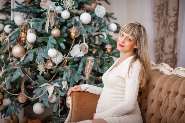 Zwangere vrouw in de buurt van een kerstboom — Stockfoto