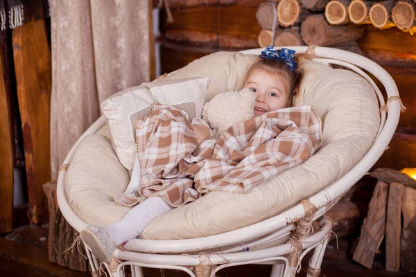 Little girl sitting in rocking near fireplace — Stock Photo, Image