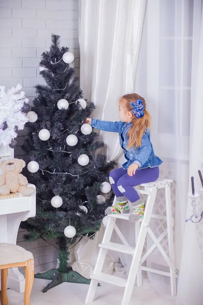 Niña con regalos cerca de un árbol de Navidad en casa —  Fotos de Stock