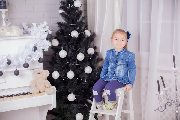 Niña con regalos cerca de un árbol de Navidad en casa —  Fotos de Stock