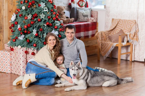 Ευτυχισμένη οικογένεια με σκύλο κοντά στο χριστουγεννιάτικο δέντρο — Φωτογραφία Αρχείου