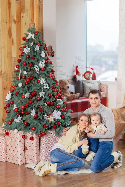 Menino perto de árvore de natal decorada com pais — Fotografia de Stock