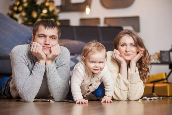 Familia feliz está acostado en el árbol de la alfombra y sonriendo —  Fotos de Stock