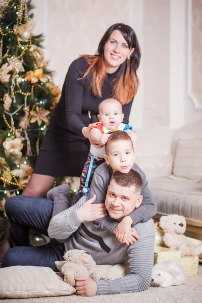 Familia sentada cerca del árbol de Navidad —  Fotos de Stock