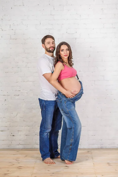 Mutlu aile baba ve hamile anne ve boş tuğla duvar odadaki yakınındaki — Stok fotoğraf