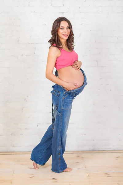 Hermosa mujer embarazada en jean en general —  Fotos de Stock