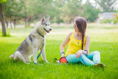 Husky metresiyle çim güneşli bir günde oturur
