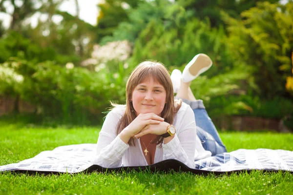 Bir kadın parkta çimlerde oturuyor — Stok fotoğraf