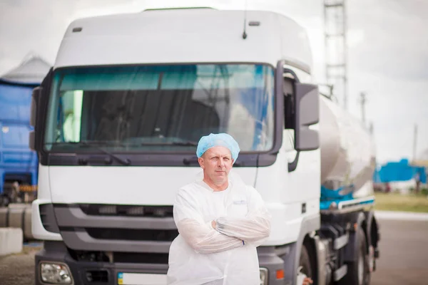 De bestuurder van de vrachtwagen van de melk in de buurt van de truck is — Stockfoto