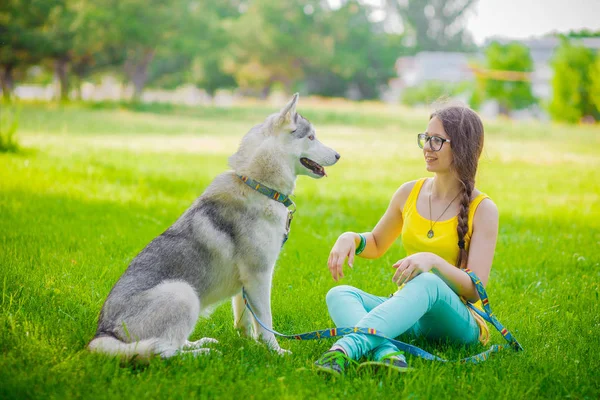 Bonita jovem esportista fazendo uma pausa de um treino para abraçar seu animal de estimação cão — Fotografia de Stock