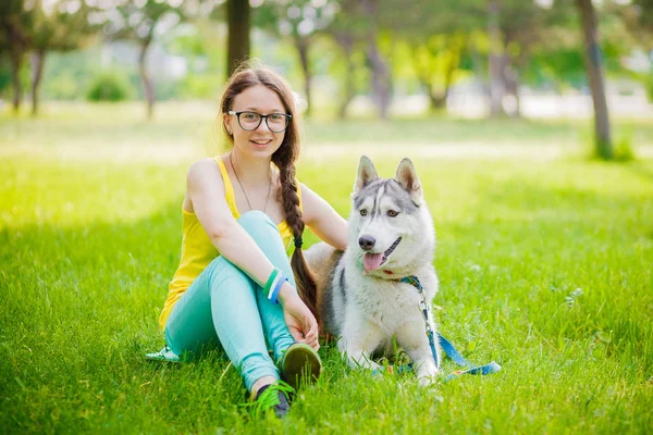 Beautiful young sportswoman taking a break from a workout to cuddle her dog pet — Stock Photo, Image