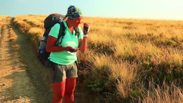 Vrouw toerist in de regen eet bessen — Stockvideo