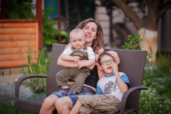 Mãe e filhos relaxando no jardim — Fotografia de Stock