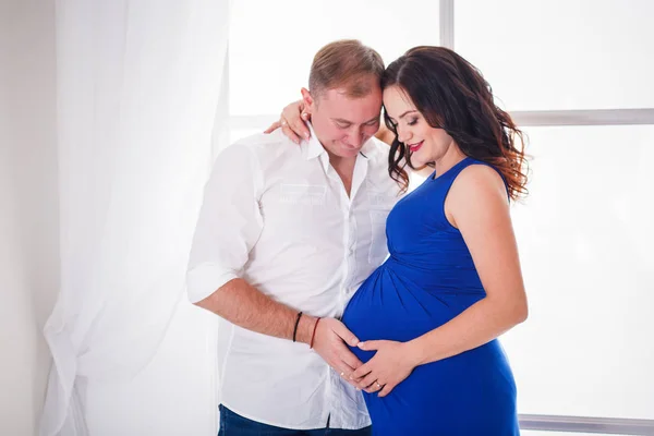 Άνδρας αγκαλιάζει μια όμορφη κοπέλα έγκυος — Φωτογραφία Αρχείου