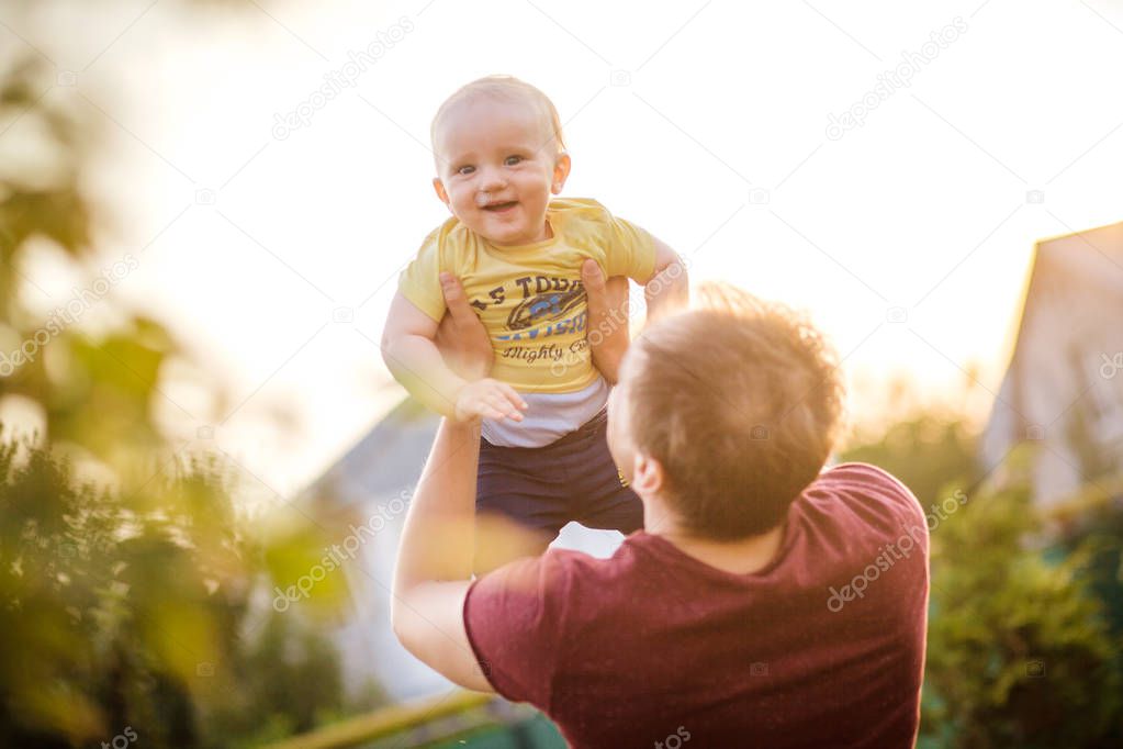 Happy dad throws small laughing son