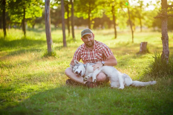 Hombre y perro Husky pasear en el parque —  Fotos de Stock