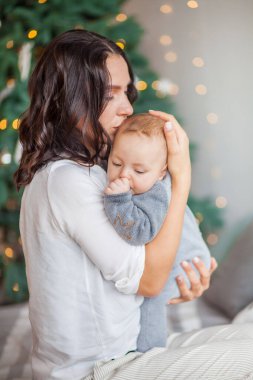 Anne yatak odasında yeni doğmuş bir bebeği öpüyor.