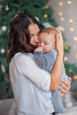 Anne, yeni doğan oğluna evde sarılıyor.
