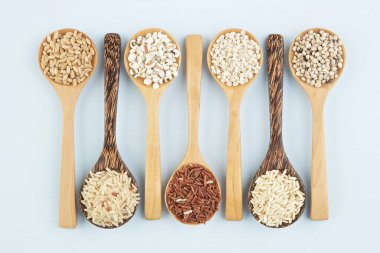 Pirinç ve wholegrains ahşap sekmesinde kaşık içinde çeşitli çeşitleri