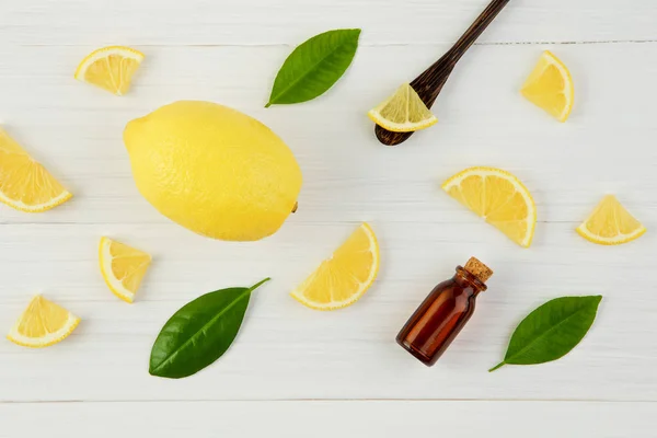 Fresh lemons and lemons leaves with essential oil on rustic wood — Stock Photo, Image