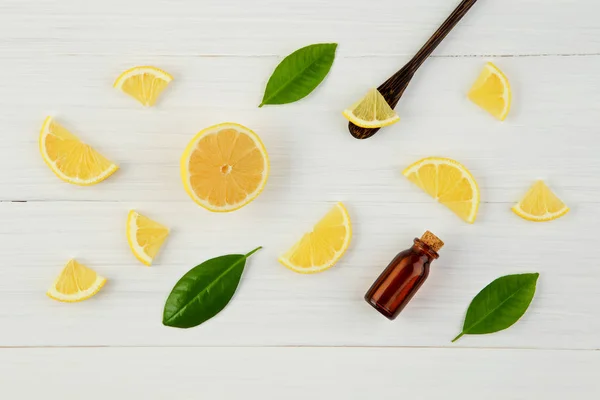 Fresh lemons and leaves with essential oil on rustic wooden back — Stock Photo, Image