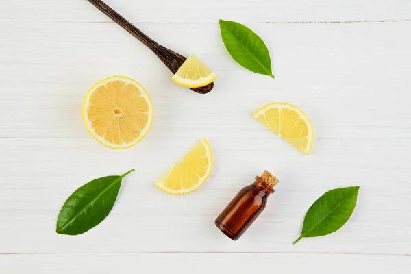 Fresh lemons and lemons leaves with essential oil on rustic wood — Stock Photo, Image