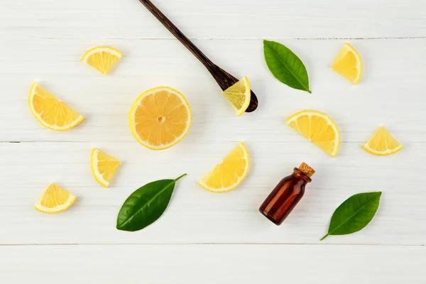 Fresh lemons and leaves with essential oil on rustic wooden back — Stock Photo, Image