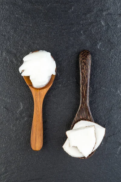 Produits à base de noix de coco maison sur cuillère en bois avec fond en pierre noire — Photo