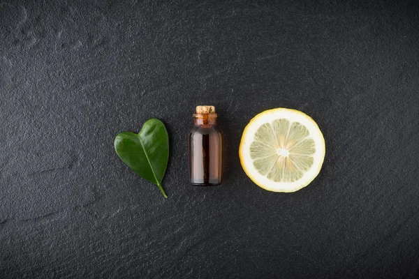 Homemade essential oil concept. Bottle essential oil with slice — Stock Photo, Image