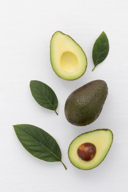 Beyaz arka plan üzerinde avokado dilimleri. Tam ve yarım bırakmak