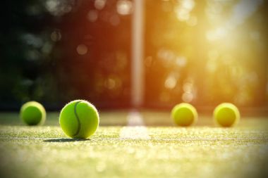 Güneş ışığı ile çim kortta tenis topları