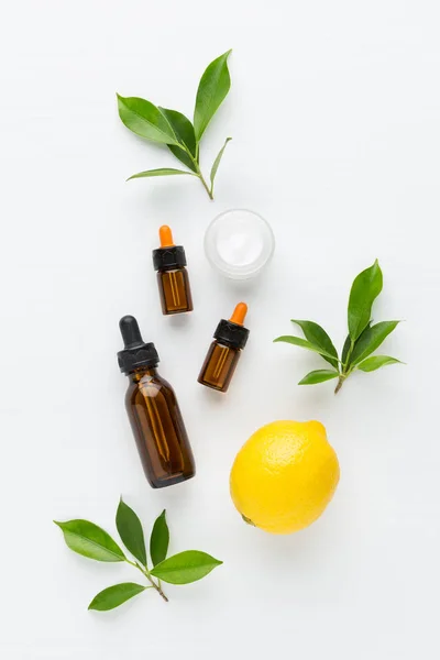 Lemon essential oil, cream on white background from top view. — Stock Photo, Image