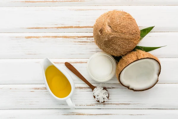 Noce di cocco con olio di cocco su sfondo bianco tavolo di legno. Bene. — Foto Stock