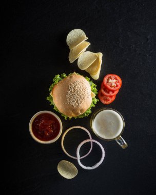 Hamburger bir bardak soğuk bira, ketçap ve d üzerinde çıtır çıtır patates kızartması ile